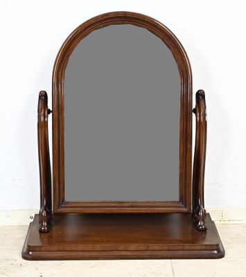 un vieux miroir en bois posé sur un socle en bois, posé sur un sol carrelé