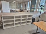 a room with a desk, shelves, and a mirror in it