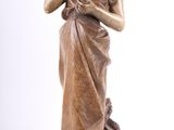 statue en bronze représentant une femme tenant un oiseau, sur fond blanc