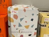 Plusieurs cartons de vin sont empilés sur une étagère dans un magasin.