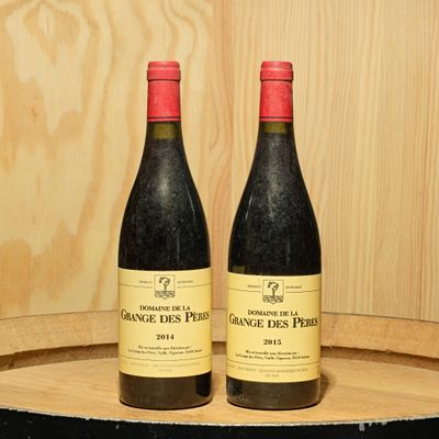 two bottles of wine sitting on a barrel of wine