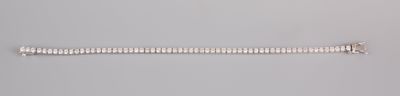 a close up of a silver bracelet on a gray surface