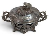 an antique silver plate with a bird on it on a white background