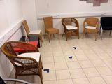 a room with chairs, tables, and a painting on the wall