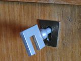 un gros plan sur la poignée d'une porte d'une armoire en bois