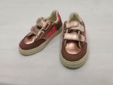 brown and pink shoes with pink trims on a white surface
