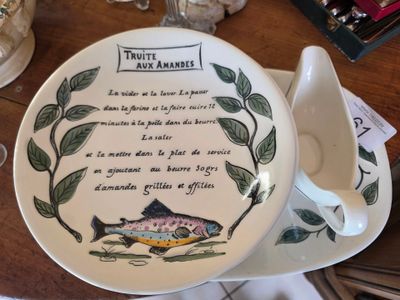 une assiette sur laquelle est posé un poisson, posée sur une table