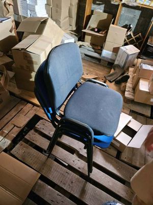 une chaise bleue posée dans une pièce remplie de cartons