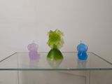 a glass table with three different colored figurines on it