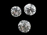 three round cut diamonds on a black background