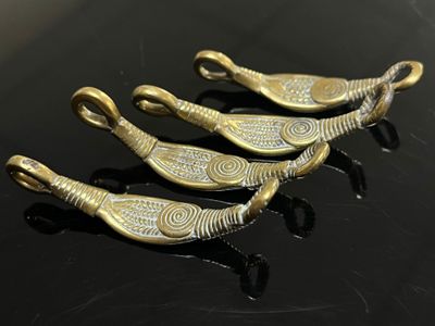 trois cuillères en métal doré posées sur une table noire