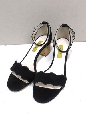 un gros plan sur une paire de chaussures noires posées sur une surface blanche
