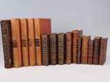 several old books are lined up in a row on a white surface