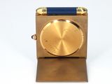 an image of a gold and blue clock on a white surface