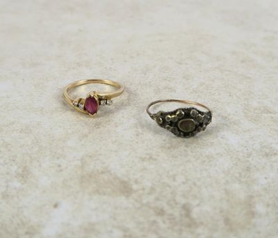 Deux bagues sont posées sur une surface blanche, avec une pierre rouge au milieu.