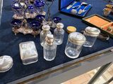 une table sur laquelle sont disposés de nombreux objets en argent et en verre