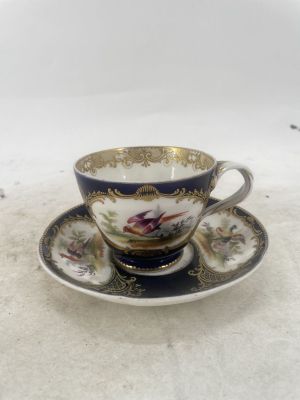 a tea cup and saucer on a white table