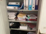 a metal cabinet with many files and binders on it