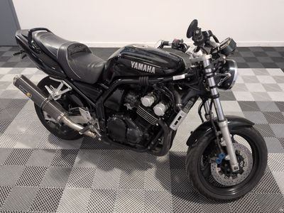 une moto noire garée sur un sol à damier