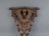 an ornately carved wooden shelf with a lion head on it