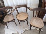three wooden chairs sitting next to each other on top of a white cloth