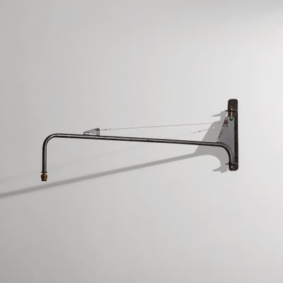 une photo en noir et blanc d'une lampe murale accrochée à un mur blanc
