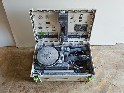 une valise contenant des outils, posée par terre