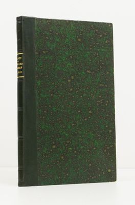 a green book sitting on top of a white table next to a white wall