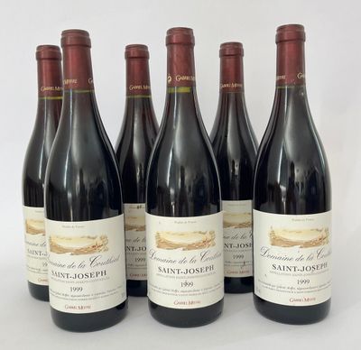 six bouteilles de vin sont alignées sur une surface blanche