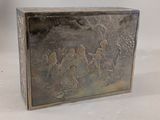 a metal box with a painting on it sitting on a table