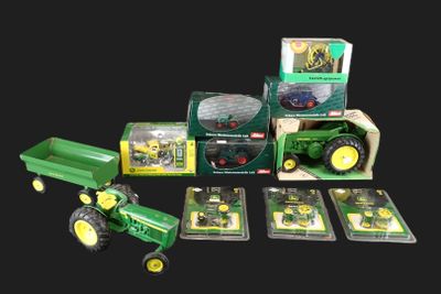 un petit tracteur vert avec une remorque et une boîte de cartes