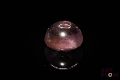 sphère de quartzite violette sur une surface noire avec reflet