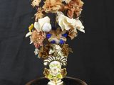 a close up of a vase with flowers in it on a black surface