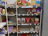 a refrigerator in the middle of a store with shelves full of food
