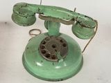 a green telephone that is sitting on a white table