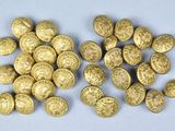 a close up of a pile of gold coins sitting on top of a table
