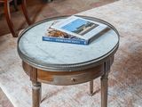 une table au plateau en marbre sur laquelle est posé un livre