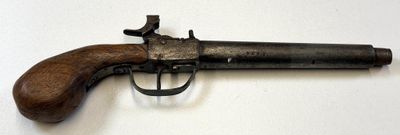 un vieux pistolet avec une poignée en bois sur une surface blanche