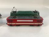 two toy trains sitting next to each other on a white surface
