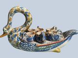 a picture of a swan shaped dish with tea cups in it