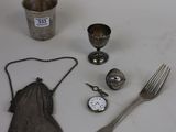 a table with silverware, a fork, a cup, and a spoon on it