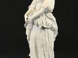 statue d'une femme en robe blanche, portant un panier sur l'épaule