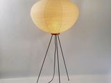the lamp is on a tripod stand with a cord attached