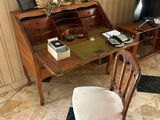 a desk with a chair and a computer on it