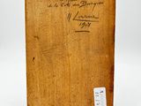 an old wooden box with writing on it sitting on a white surface