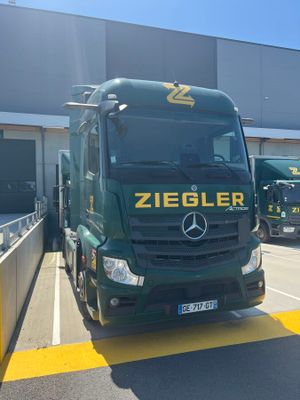 a green truck that is parked in front of a building