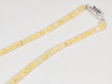 yellow beaded necklace with multi colored beads on a white surface