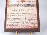 a small wooden plaque with a picture of a map on it
