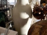 a white vase sitting next to a sink in a room
