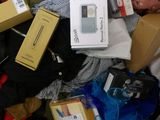 a pile of clothing and a cell phone on a bed